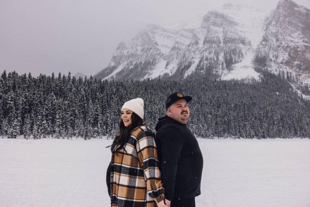 couple standing on lake louise in the winter