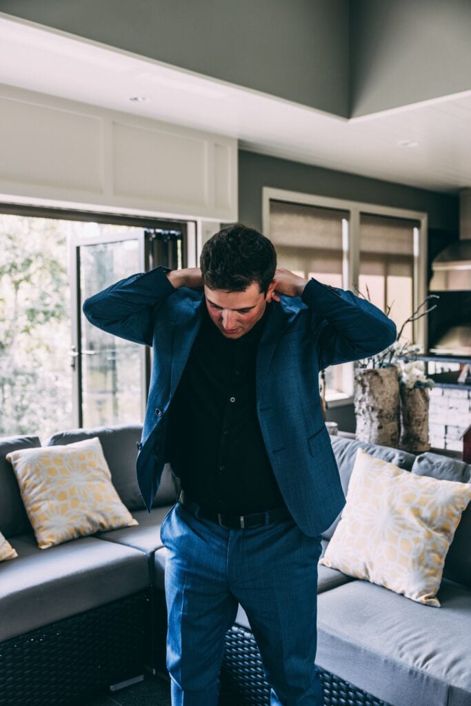 groom getting ready for his backyard elopement