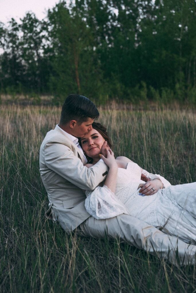 couple cuddling in a field 