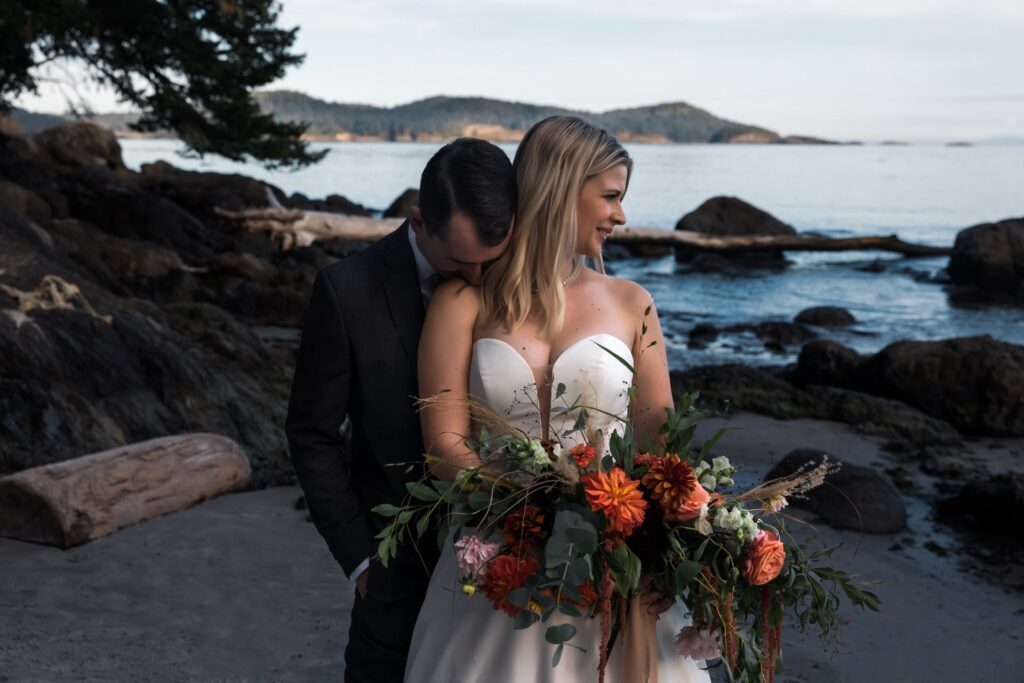 groom kissing brides shoulder in vancouver island