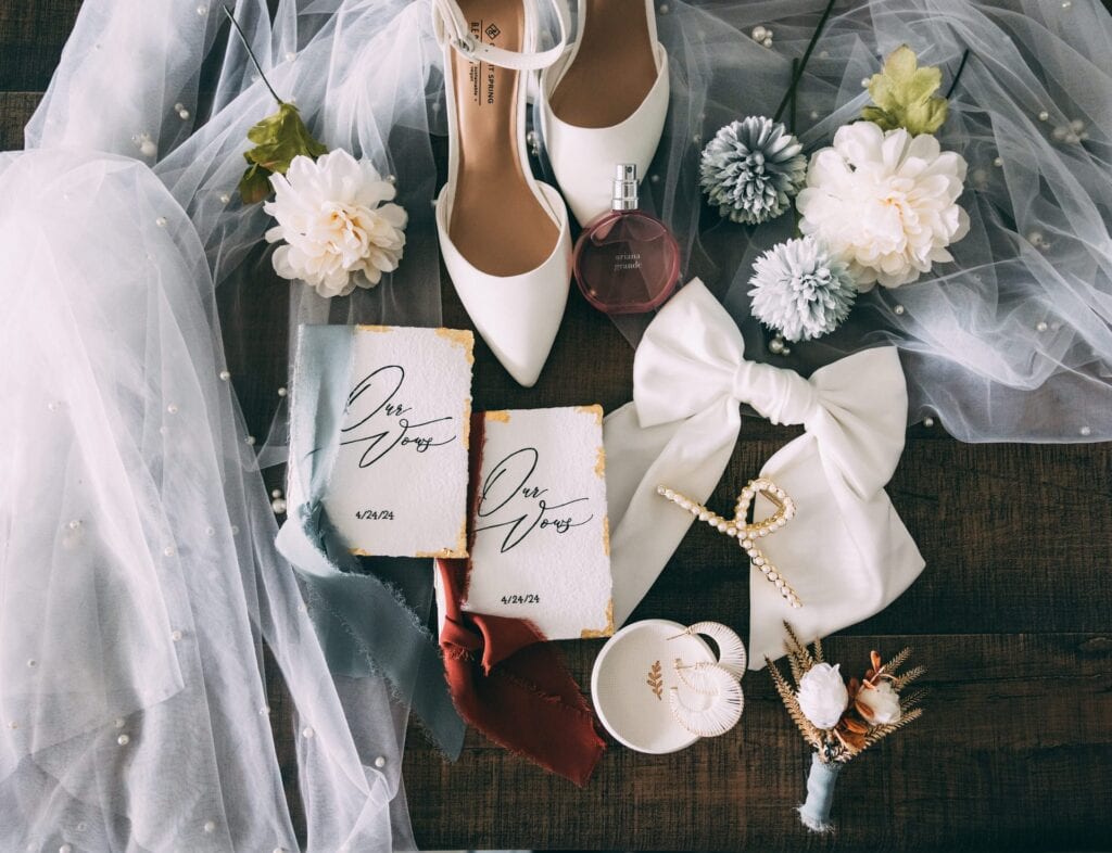 elopement flat lay details; ring dish, elopement shoes, vow books, florals