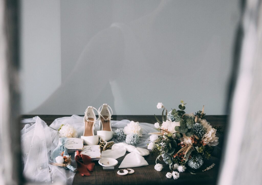 elopement flat lay details; ring dish, elopement shoes, vow books, florals