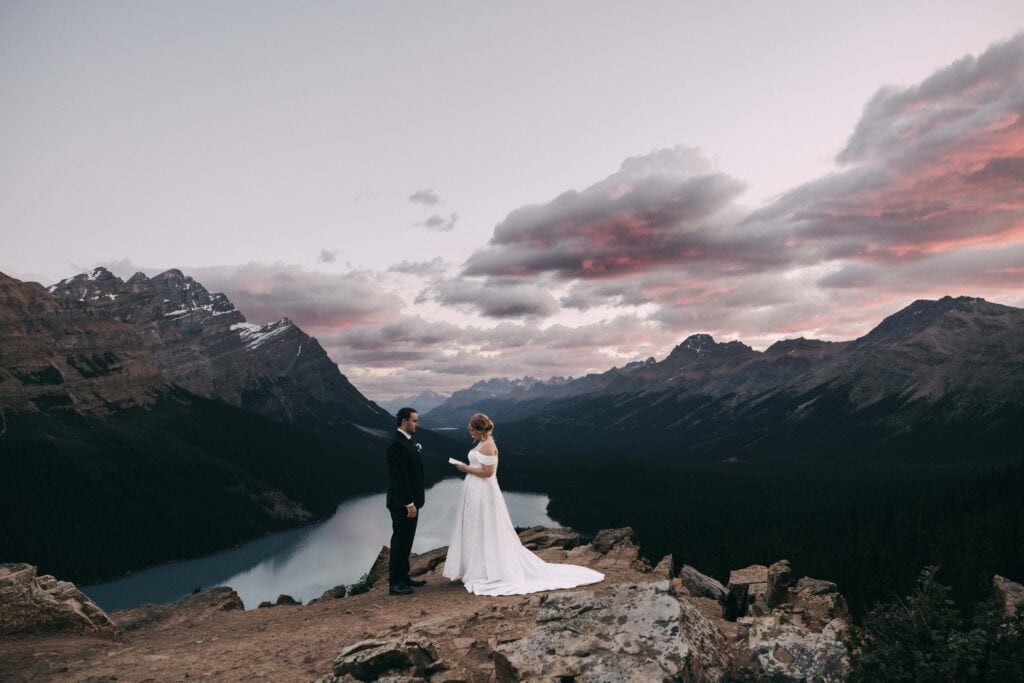 couple reading vows at sunrise at peyto lake in banff national park